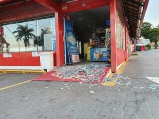 Estilhaços de vidro ficaram espalhados pelo acesso à loja e calçada (Foto: Clayton Neves)