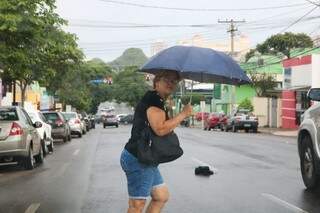 Prevenida, mulher já abriu o guarda chuva no centro de Campo Grande (Foto: Marcos Maluf)