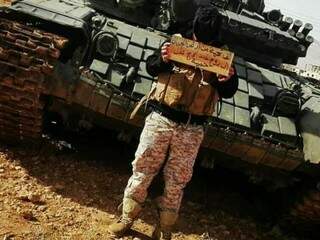 Hassan na frente de um tanque. (Foto: Arquivo Pessoal).