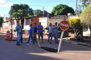 Revoltados com descaso, moradores arrancaram placa para sinalizar buraco (Foto: Alcides Neto)