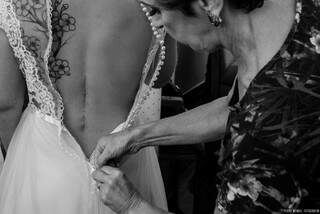 Jaqueline com a mãe a abotoar os botões do vestido e a cicatriz que carrega de um grande marco na vida. (Foto: Pedro Wendel Fotografia)