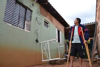 Machucado, Carlos mostra as paredes rachadas e as janelas queimadas. (Foto:Minamar Júnior)
