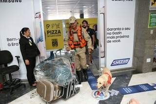 O sargento carregando as bagagens e guiando a Cindy no aeroporto (Foto: Paulo Francis)