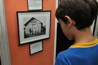 Estudante observa foto antiga do distrito de Itahum no museu de Dourados (Foto: A. Frota)