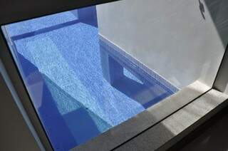 Pelo vidro é possível já ver e se deliciar com a imagem da área de lazer da casa. 