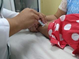 Profissional aplicando dose da vacina contra a gripe (Foto: Sesau)