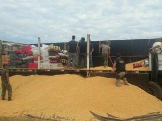 Para constatar o transporte das drogas, foi preciso descarregar os milho levado na carreta (Foto: Divulgação/PRF)