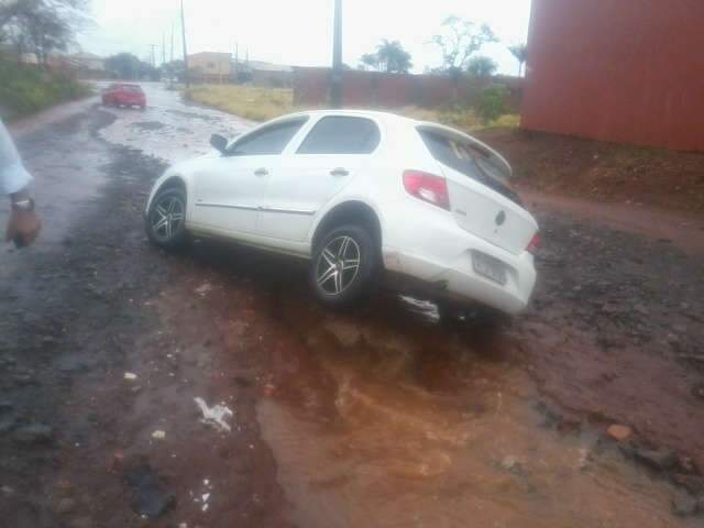  Rua vira rio, motorista n&atilde;o v&ecirc; buraco, carro cai e fica com rodas para cima