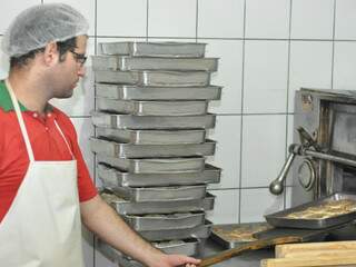 Funcionário tira esfirras do forno da Confeitaria Árabe. (Foto: Marlon Ganassin)