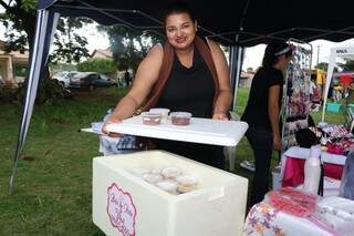 Viviane Aline Silva mostrando os bolos de pote que levou para vender na feira (Foto: Marcos Maluf)