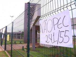 Cartaz fixado por manifestantes na entrada da UEMS em Campo Grande (Foto: Marcos Ermínio)