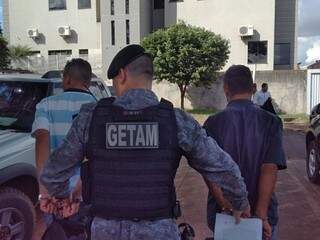 Goianos presos com supermaconha são conduzidos por policial militar (Foto: Adilson Domingos)