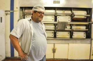 Adriano ao lado do forno a lenha, que é usado até hoje na produção dos pães. (Foto: Alcides Neto)