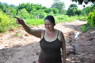 Rosângela apotna para obra de canalização, cem metros após rua tomada por buracos. (João Garrigó).