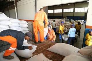 Os servidores da Seintrha descarregam a primeira carreta com 20,5 mil quilos de feijão na Suali (Foto: Fernando Antunes)