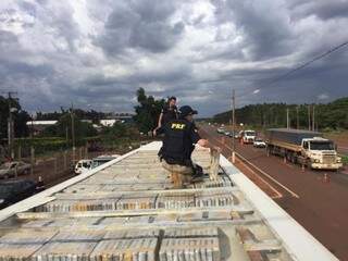 Policiais tirando os tabletes de maconha de cima do caminhão. (Foto: Divulgação) 