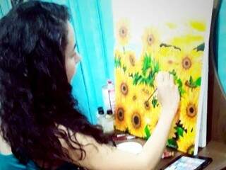 Naiara Nascimento Rodrigues pintando os girassóis na tela. (Foto: Arquivo pessoal)