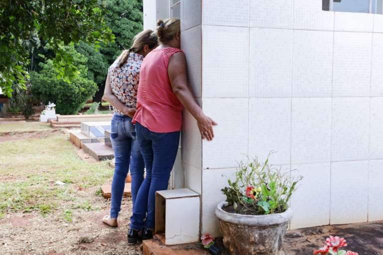 Mãe e filha, Enir (de rosa) e Queila (ao lado) durante visita ao túmulo onde estão enterrados a mãe e o irmão de Enir (Foto: Kísie Ainoã)