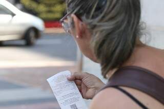 Consumidora observa nota fiscal ao comprar no Centro da Capital (Foto: Marcos Maluf)