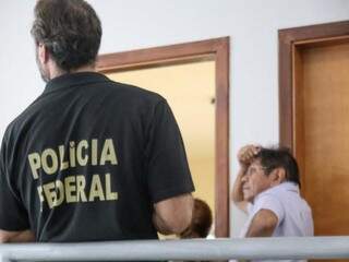 Policial federal guarda vista onde indígena leva a mão na cabeça na sede da Funai em Campo Grande (Foto: Marcos Maluf)