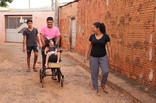 A família levando Manu para passear perto da casa onde moram (Foto: Kísie Ainoã)