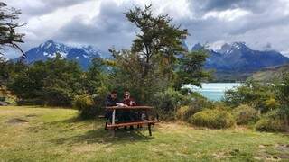 Casal almoçando em uma paisagem que parece pintura. (Foto: Arquivo Pessoal)