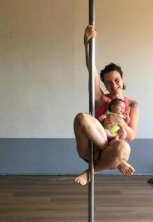 Kristiane Coelho Corrêa treinando pole dane com a filha Olívia no colo (Foto: Arquivo pessoal)