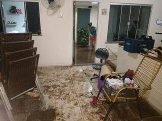 Moradora limpando a casa depois da enxurrada ter invadido a varanda e sala (Foto: Fernanda Palheta)