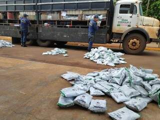 Policiais retiram pacotes de agrotóxico de caminhão apreendido nesta tarde em Itahum (Foto: Adilson Domingos)