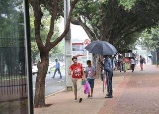 Cícero oferecendo guarda-chuva para quem passa na rua. (Foto: Paulo Francis)
