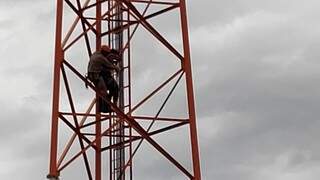 Momento em que bombeiro descia da torre com a mulher presa ao corpo (Foto: Adilson Domingos)