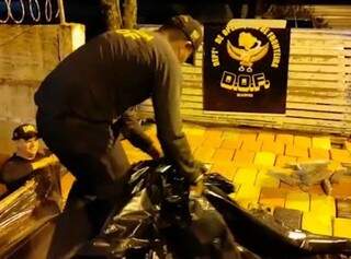 Policial retira cobertura que camuflava carregamento de maconha. (Foto: Divulgação)