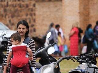 Na fronteira entre Brasil e Paraguai, uma mãe paraguaia carrega a filha em dia de visita no presídio de Pedro Juan Caballero. (Foto: Marcos Maluf)