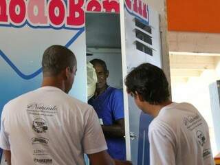 O morador de rua dentro da cabine do banho que é fechada pelos voluntários para que ele possa se lavar (Foto: Marcos Maluf)