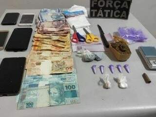 Dinheiro, celulares e drogas apreendidos com os suspeitos. (Foto: Nova Notícias)
