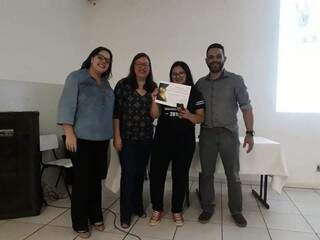 Ao lado de professores e com certificado de aluna destaque nas mãos, Yasmin hoje comemora primeiro lugar na UFMS (Foto: Divulgação) 