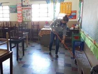 Funcionária de escola limpando sala de aula com máscara de proteção. (Foto: Letícia Barros/ABC Color) 