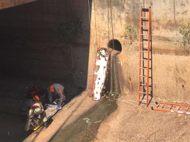 Mulher fica pendurada em grade, cai em c&oacute;rrego e &eacute; resgatada 