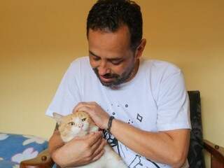 O gato foi adotado pela segunda vez e agora recebe o carinho de Gustavo Amorim de Deus (Foto: Marcos Maluf)