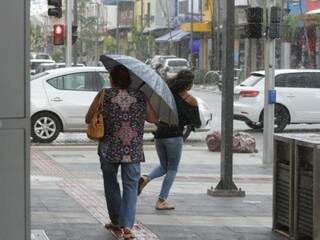 Mulheres tentam escapar da chuva na 14 de Julho (Foto: Marcos Maluf)