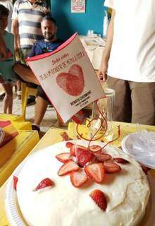 Bolo de aniversário com morango e plaquinha incentivando os convidados a serem doadores de medula (Foto: Arquivo Pessoal)