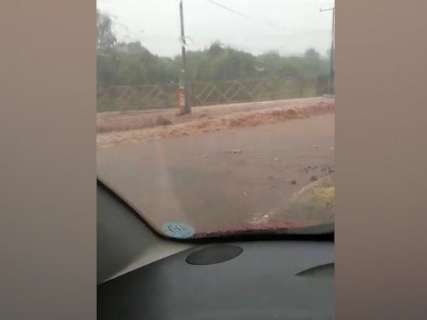 Motorista fica ilhado em calçada para escapar de enxurrada no Nova Lima