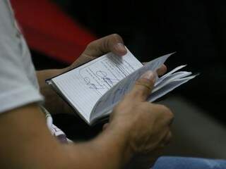 Trabalhador confere Carteira de Trabalho enquanto aguarda atendimento na Funtrab (Foto: Marcos Maluf/Arquivo)