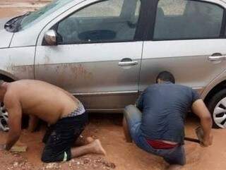 Homens tentam desatolar carro no Aero Rancho (Foto: Direto das Ruas)