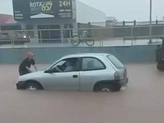 Carro ficou com água até metade dos pneus durante a chuva em Água Clara. (Foto: Direto das Ruas)