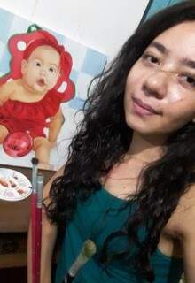 Naiara fazendo selfie com o quadro de um bebê que acabou de pintar. (Foto: Arquivo pessoal)