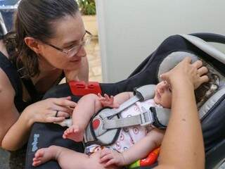 A pequenina Noemi com a mão da terapeuta Patrícia Iasuda colocando as sementinhas sob o olhar atento e carinhoso da mãe Sonia. (Foto: Paulo Francis)