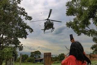 Moradora não resiste e mete logo o celular para fazer fotos do helicóptero pousando (Foto: Marcos Maluf)