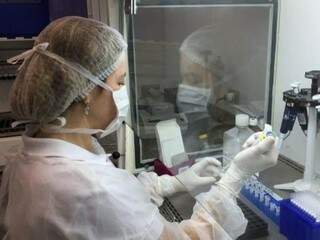 Funcionária manipula material no Lacen, que passará a fazer testes do coronavírus. (Foto: Divulgação)