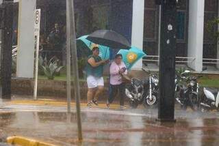 Guarda chuva serviu pra duas que perambulavam pelo centro na hora que a chuva caiu (Foto: Marcos Maluf)